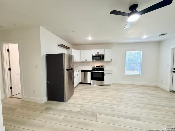 a view of kitchen with stainless steel appliances granite countertop cabinets and refrigerator