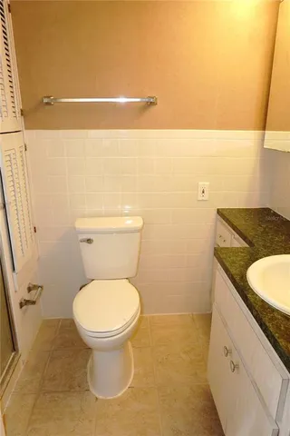 a bathroom with a granite countertop toilet and a sink
