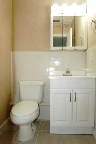 a bathroom with a toilet sink and mirror