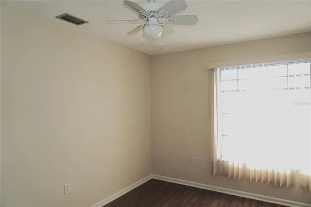 a view of a small space with wooden floor and a window