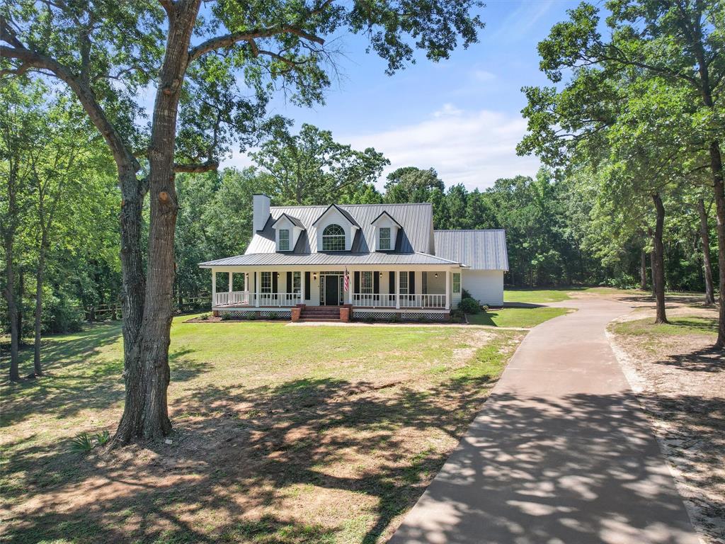 a view of a house with a yard and large tree