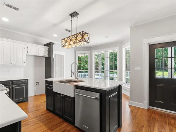 a kitchen with stainless steel appliances granite countertop a sink a stove a refrigerator and wooden floor