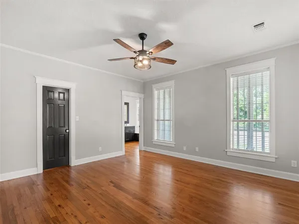 a view of an empty room with window and wooden floor