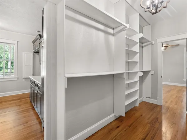 a view of a hallway with wooden floor and closet