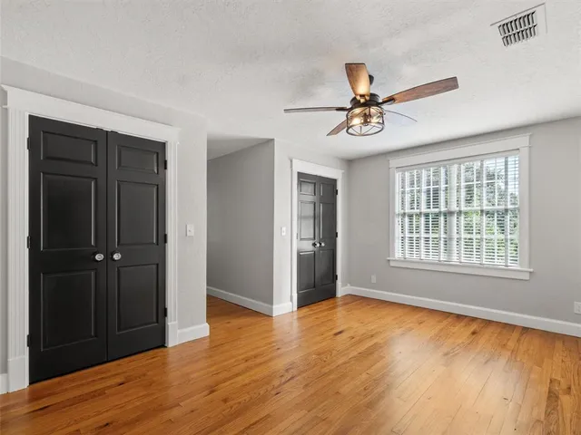 a view of empty room with wooden floor