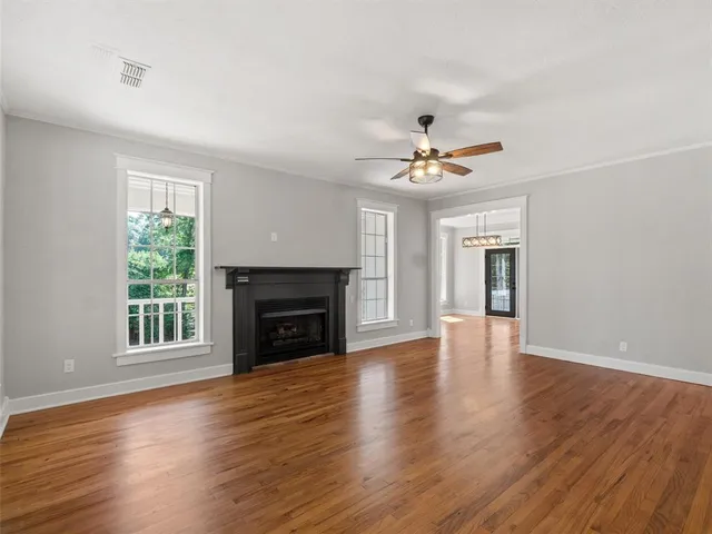 a view of livingroom with fireplace window and wooden floor