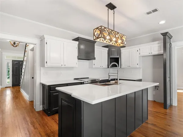 a kitchen with a center island wooden floor and stainless steel appliances