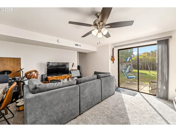 a living room with furniture a flat screen tv and a large window