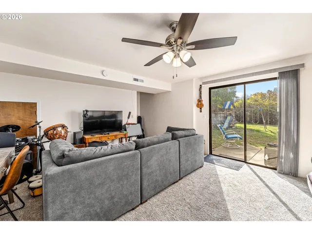a living room with furniture a flat screen tv and a large window