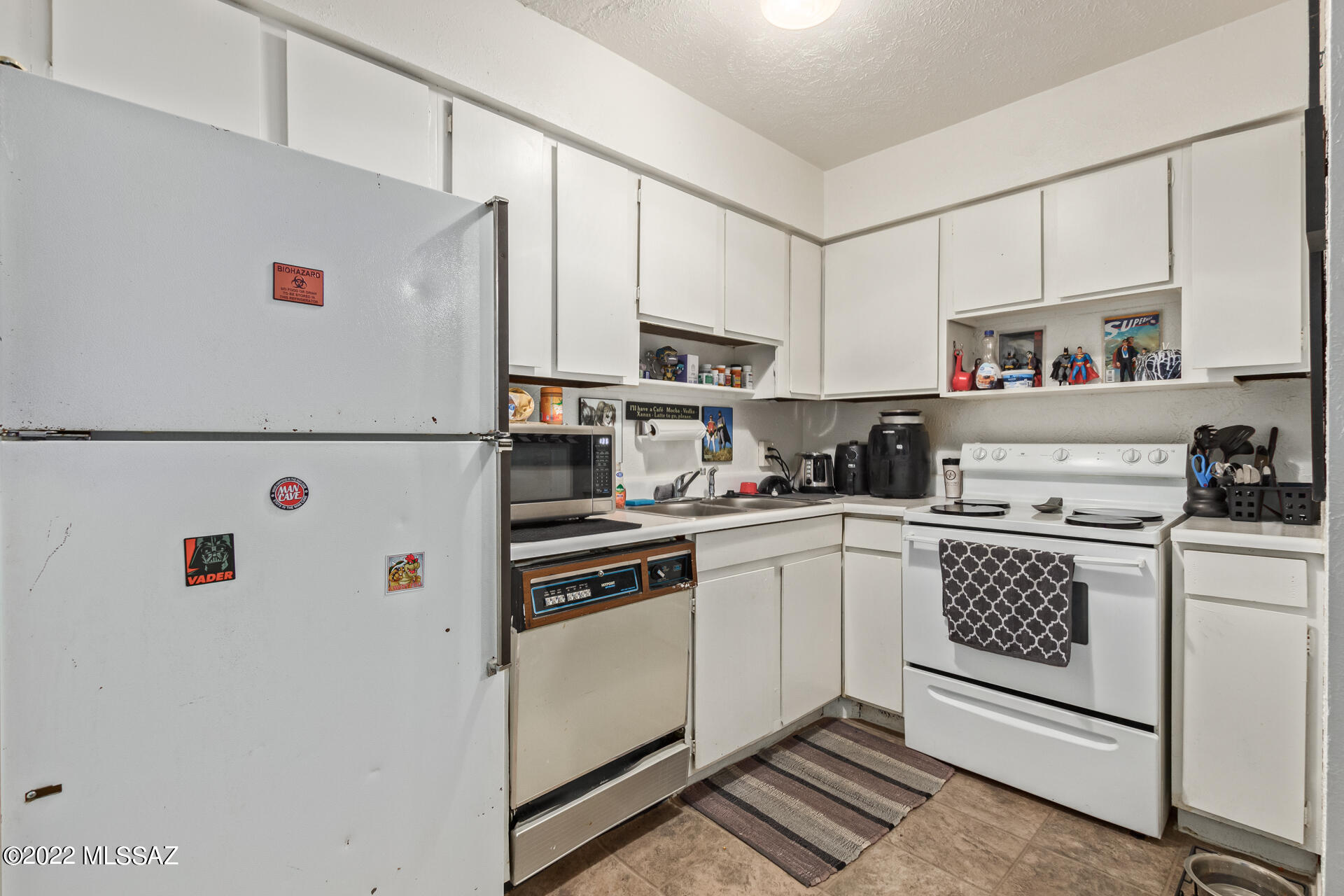 1620 North Wilmot Road, Unit D273 Tucson, AZ 85712 - Photo 8 of 15 a white kitchen with cabinets a sink and white appliances