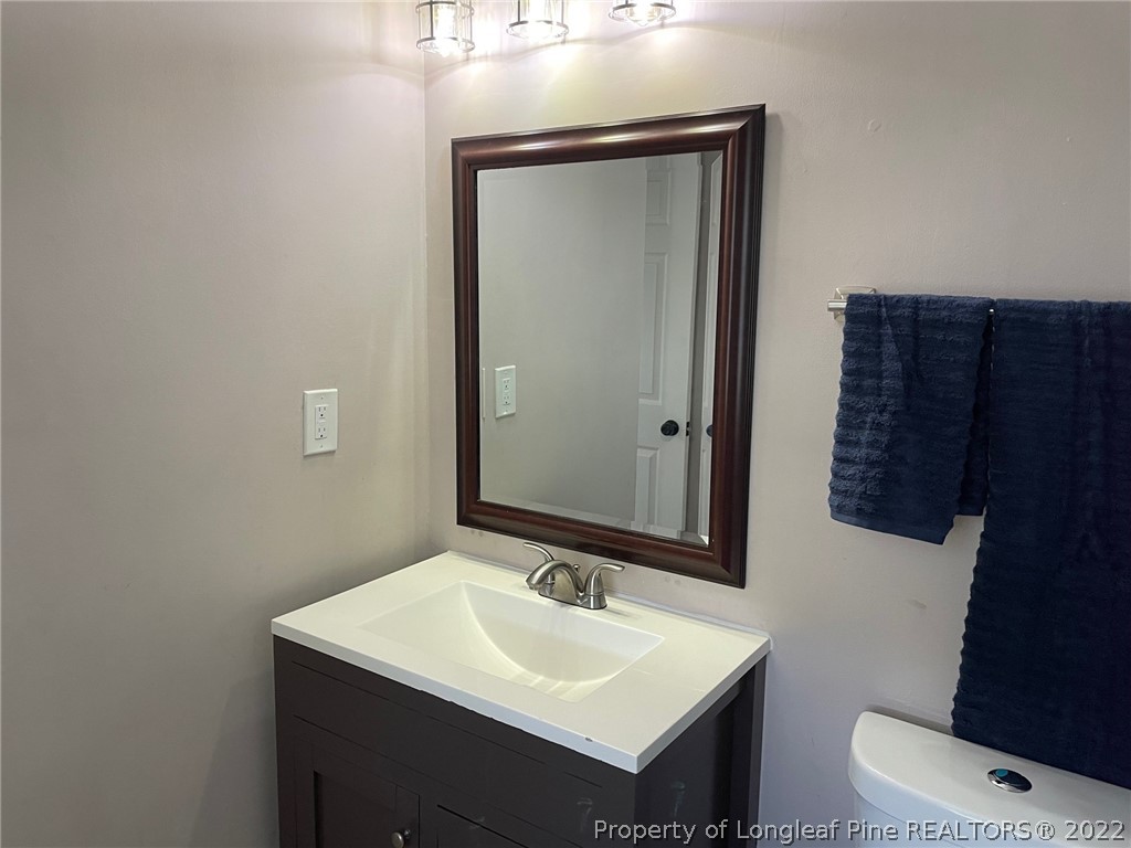 1714 Valley Ridge Drive Fayetteville, NC 28303 - Photo 16 of 32 a bathroom with a sink a toilet and mirror
