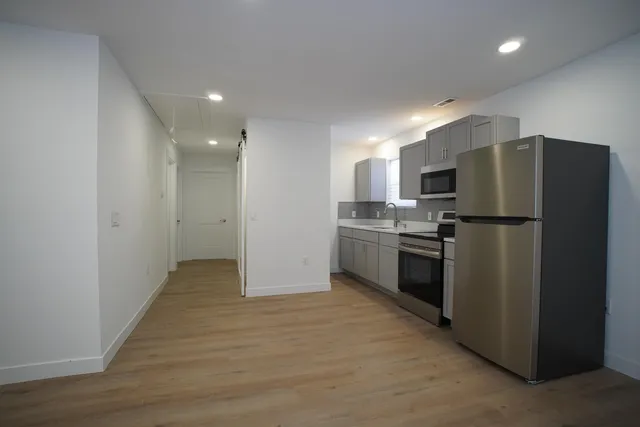 a kitchen with a refrigerator a sink and cabinets
