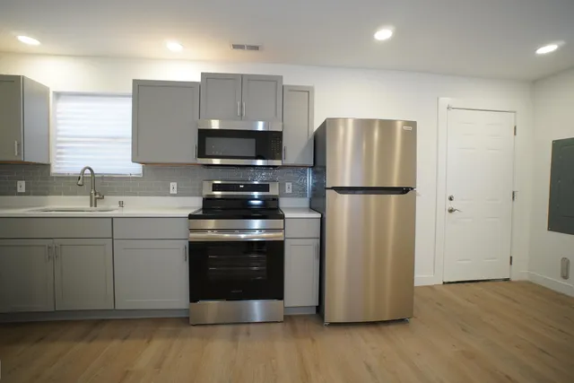 a kitchen with a refrigerator sink and cabinets