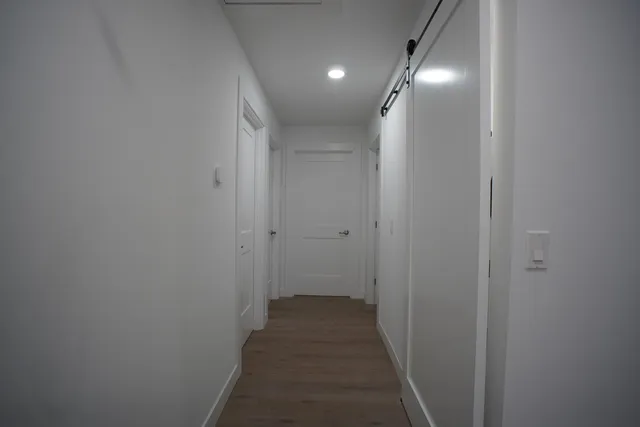 a view of a hallway with wooden floor