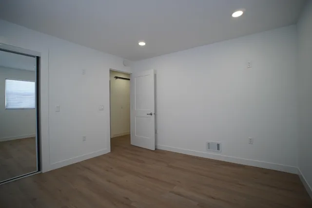 an empty room with wooden floor and closet