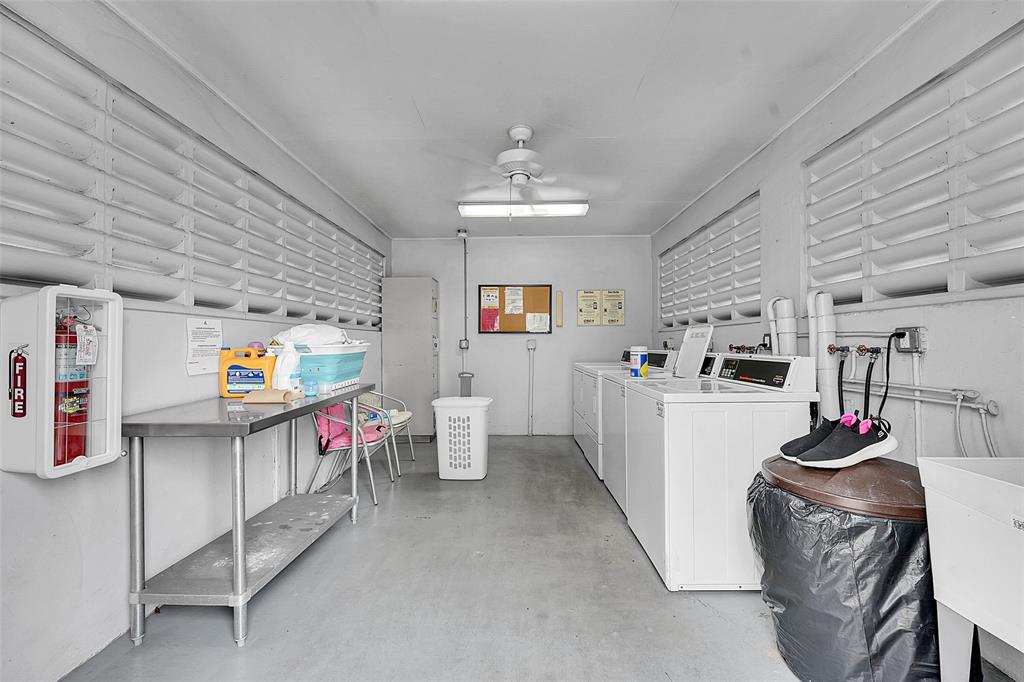 2769 Ashley Drive West, Unit F West Palm Beach, FL 33415 - Photo 19 of 25 a living room with furniture and a chandelier