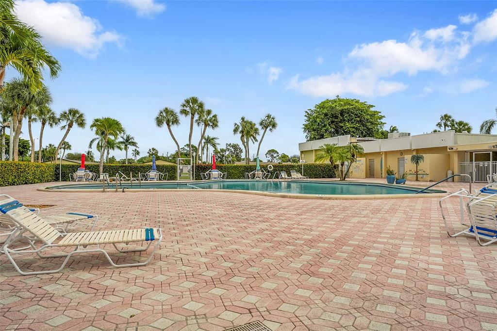 2769 Ashley Drive West, Unit F West Palm Beach, FL 33415 - Photo 24 of 25 a view of swimming pool with outdoor seating and plants