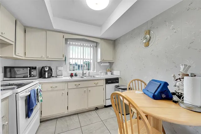 a kitchen with a sink white cabinets and stainless steel appliances