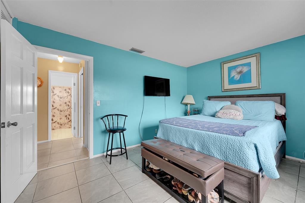 2769 Ashley Drive West, Unit F West Palm Beach, FL 33415 - Photo 10 of 25 a bedroom with furniture and a painting