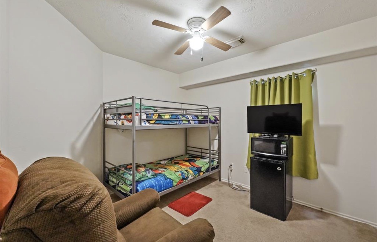 13134 Peppergate Lane Houston, TX 77044 - Photo 18 of 23 a bedroom with furniture and a flat screen tv