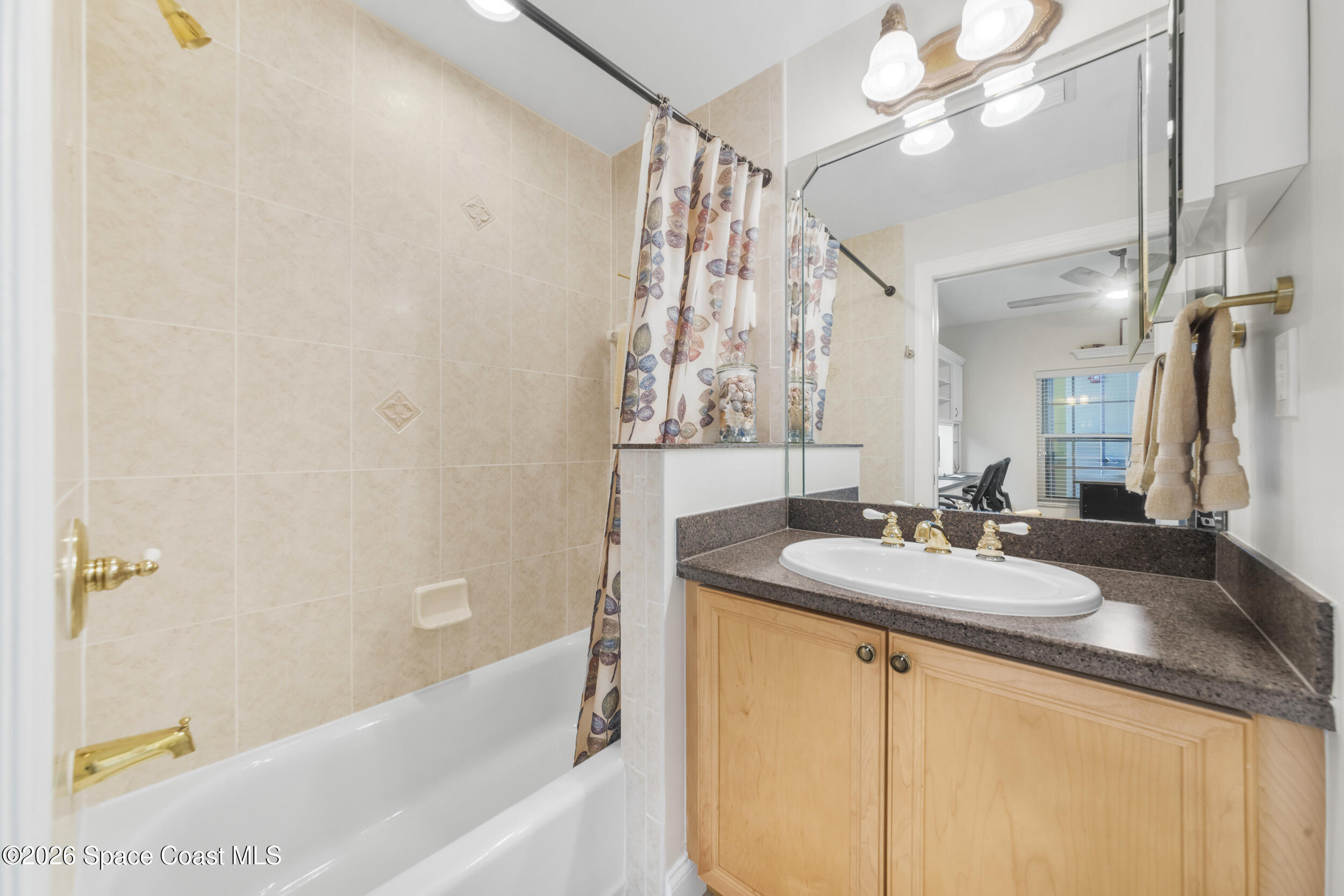 4955 Dixie Highway Northeast, Unit 702 Palm Bay, FL 32905 - Photo 14 of 54 a bathroom with a granite countertop sink a mirror and a bathtub