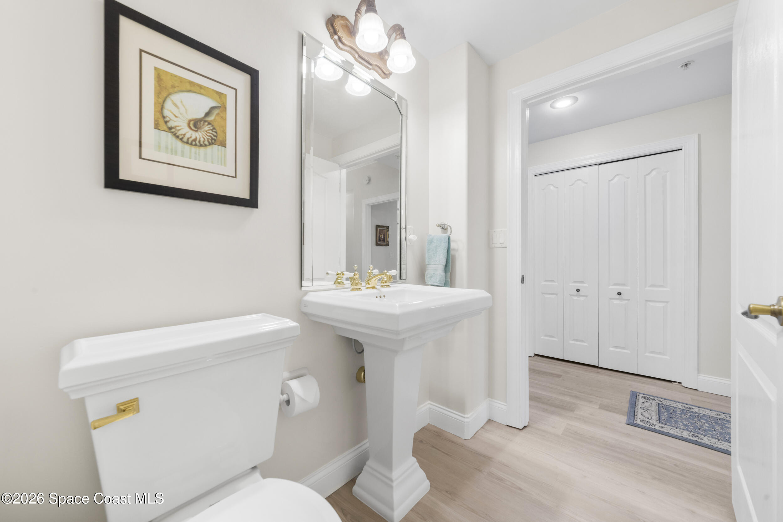 4955 Dixie Highway Northeast, Unit 702 Palm Bay, FL 32905 - Photo 15 of 54 a bathroom with a toilet a sink and mirror