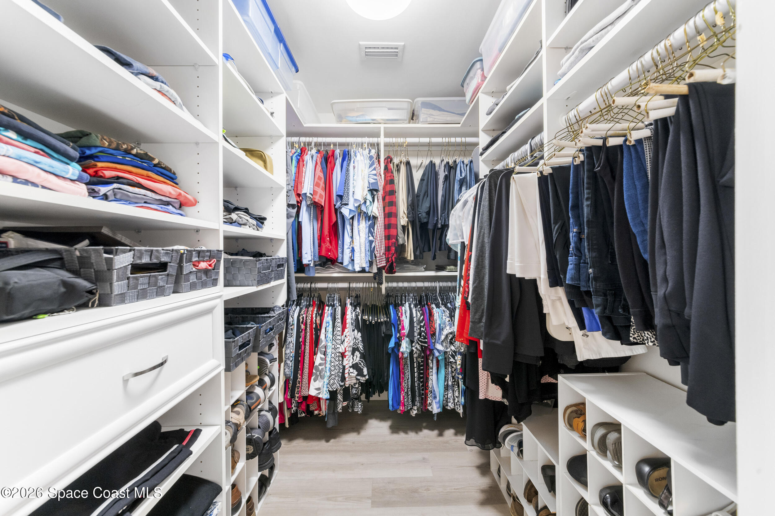 4955 Dixie Highway Northeast, Unit 702 Palm Bay, FL 32905 - Photo 36 of 54 a view of walk in closet with clothes and shoes