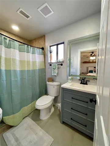 a bathroom with a sink a toilet a mirror and shower