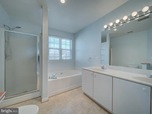 a spacious bathroom with a double vanity sink and mirror