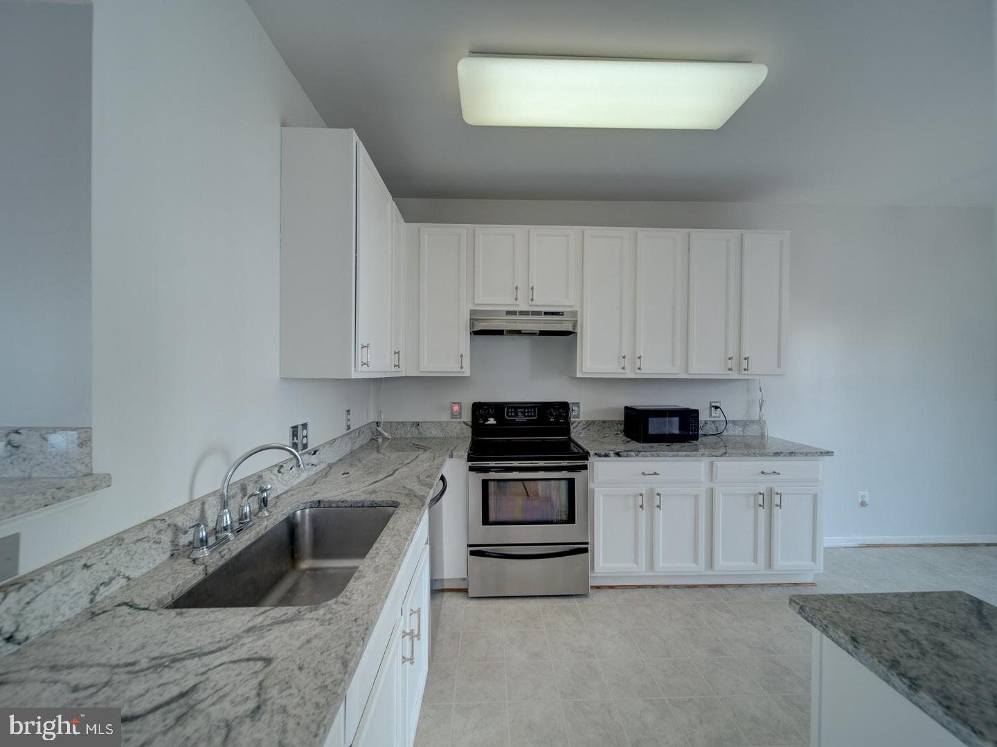 4016 Tidewood Road Baltimore, MD 21220 - Photo 9 of 40 a kitchen with granite countertop a sink a stove and cabinets