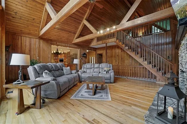 a open kitchen with stainless steel appliances kitchen island granite countertop a table chairs and a refrigerator