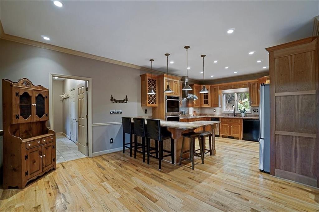188 Tea Berry Lane Jasper, GA 30143 - Photo 15 of 68 a open kitchen with stainless steel appliances kitchen island granite countertop a table chairs and a refrigerator