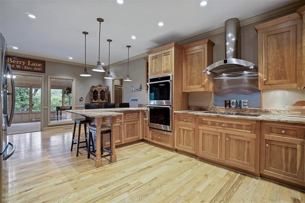 188 Tea Berry Lane Jasper, GA 30143 - Photo 17 of 68 a kitchen with stainless steel appliances granite countertop a stove a sink dishwasher a dining table and chairs with wooden floor