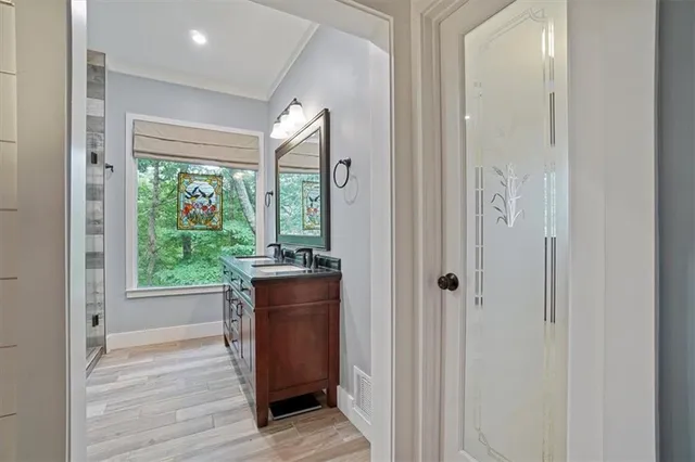 a bathroom with a granite countertop sink a mirror and shower
