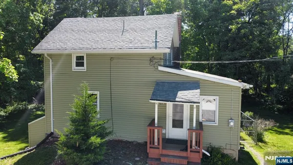 a view of a house with a yard and potted plants