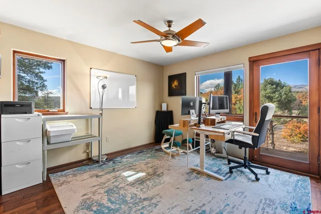 a work room with furniture wooden floor and a window