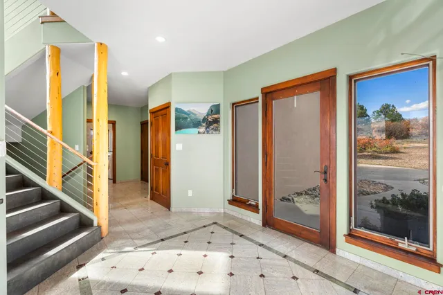 a view of a hallway with wooden floor and a living room
