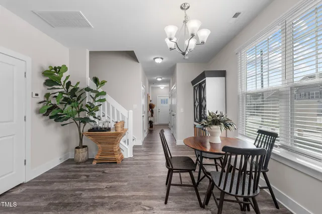 a view of a dining room with furniture and chandelier