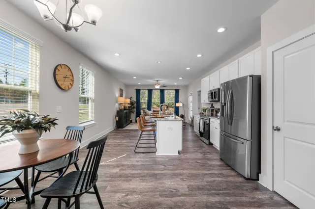 a large kitchen with a table and stainless steel appliances