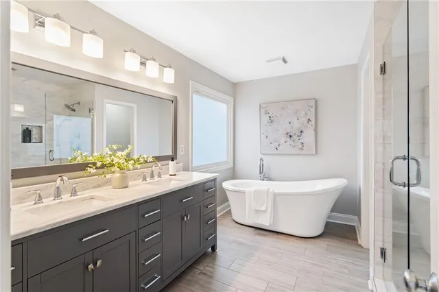 a spacious bathroom with a double vanity sink mirror and bathtub