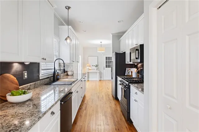 a kitchen with stainless steel appliances granite countertop a stove and a sink