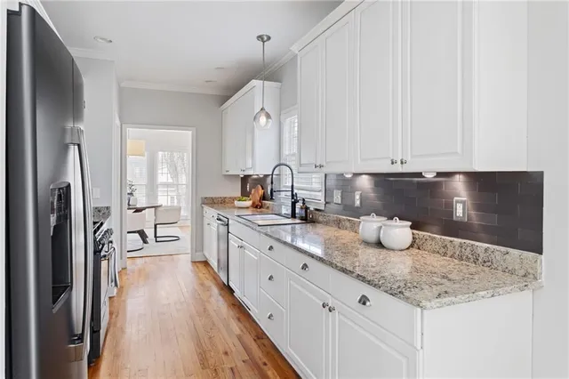 a kitchen with sink a refrigerator and cabinets