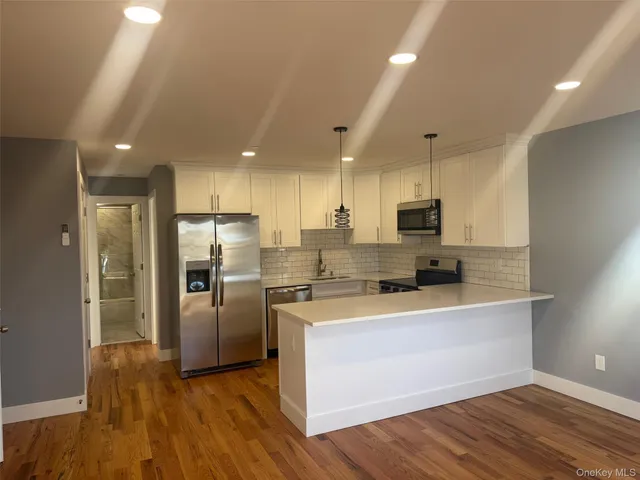 a kitchen with stainless steel appliances a refrigerator and a stove top oven