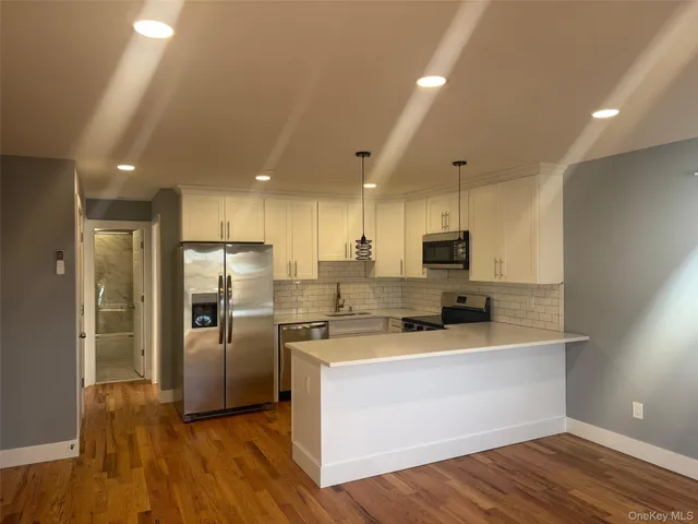 a kitchen with stainless steel appliances granite countertop a sink a refrigerator and a stove top oven