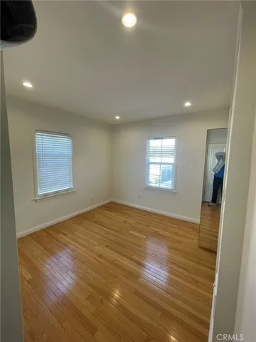 an empty room with wooden floor and chandelier
