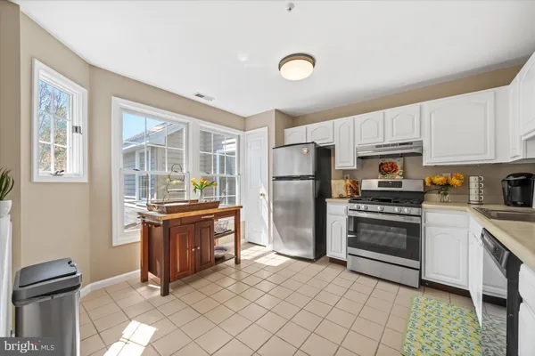 a kitchen with granite countertop a refrigerator stove top oven and sink