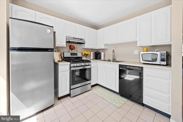 a kitchen with white cabinets and stainless steel appliances