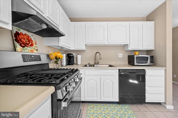 a kitchen with stainless steel appliances granite countertop a stove a sink and cabinets