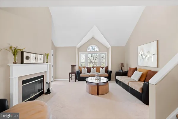 a living room with furniture a fireplace and a large window
