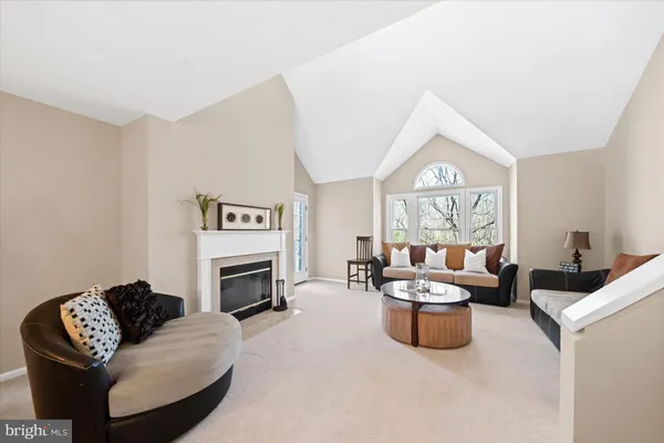 a living room with furniture a fireplace and a window